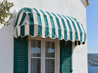 Green and white striped capotina awning over a window with green shutters